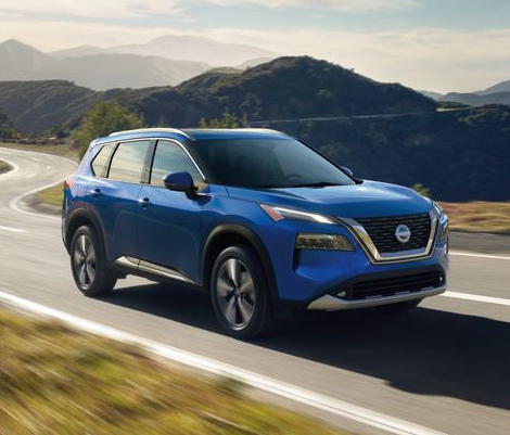 Blue Nissan car running on the road betwenn mountains