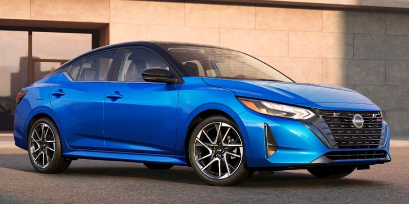 Blue Sentra is stands front of building area rightand front view