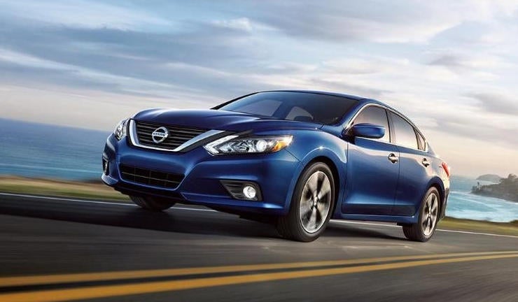 Blue Nissan in motion on an open highway